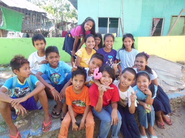 Group of smiling kids outside a community nursing event